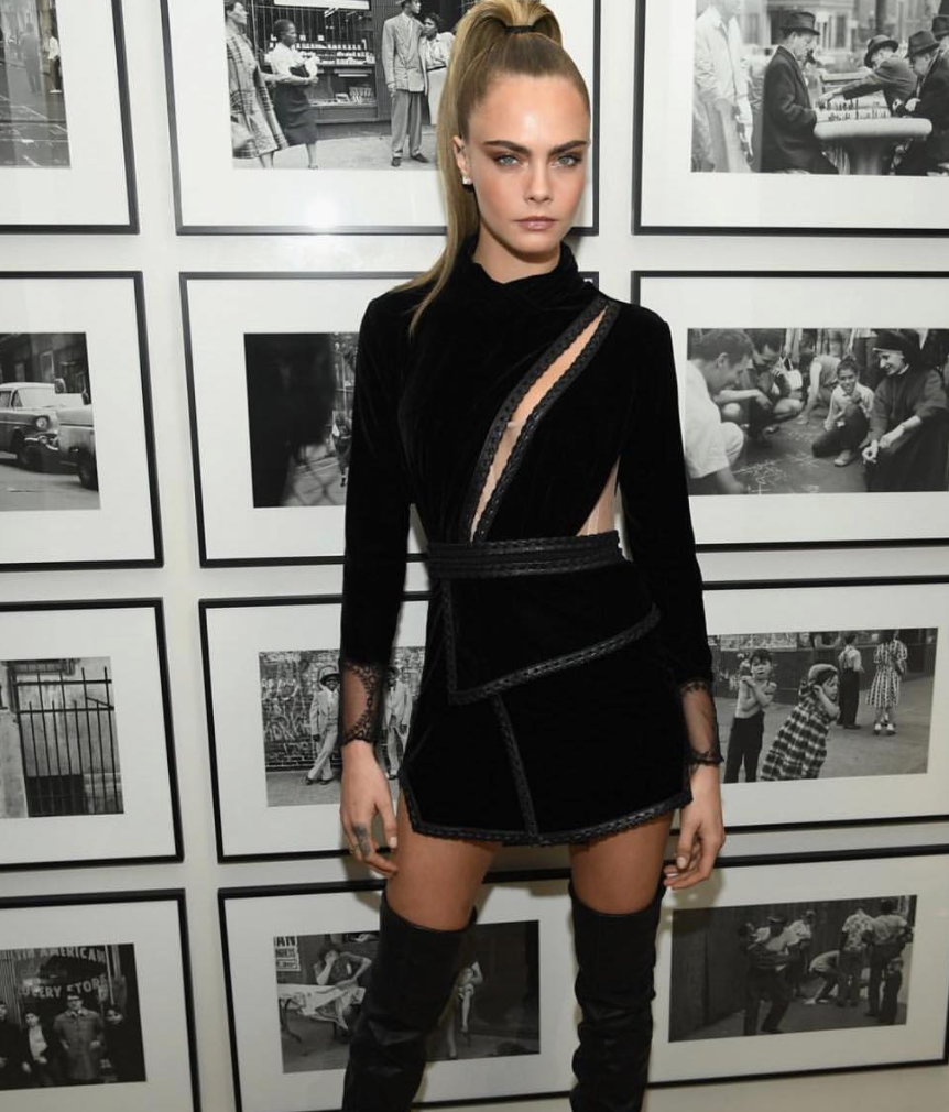 Supermodel Cara Delevingne at an event against a gallery background