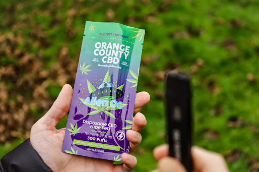 orange county cbd green and purple Alien OG plastic packaging and black disposable vape pen 