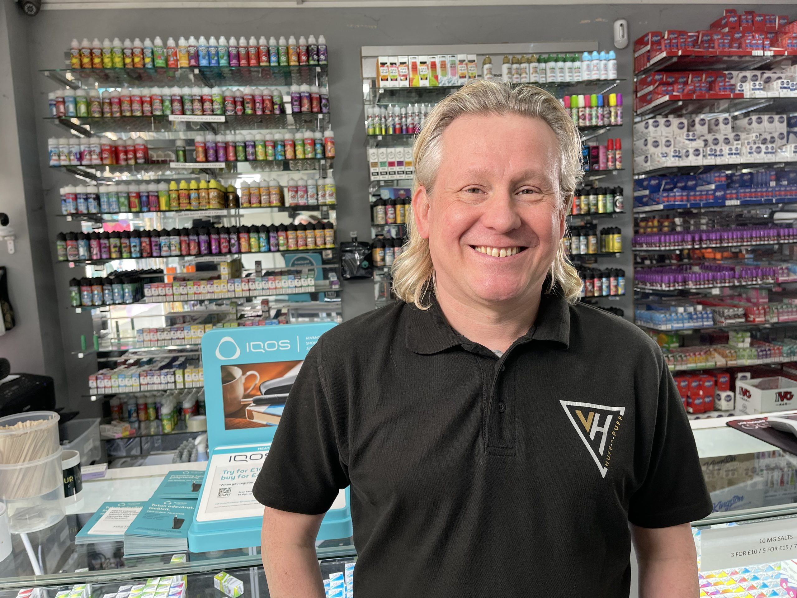 lee howard, store manager at the vapourhut limited, stood in his vape shop infront of shelves of e-liquids